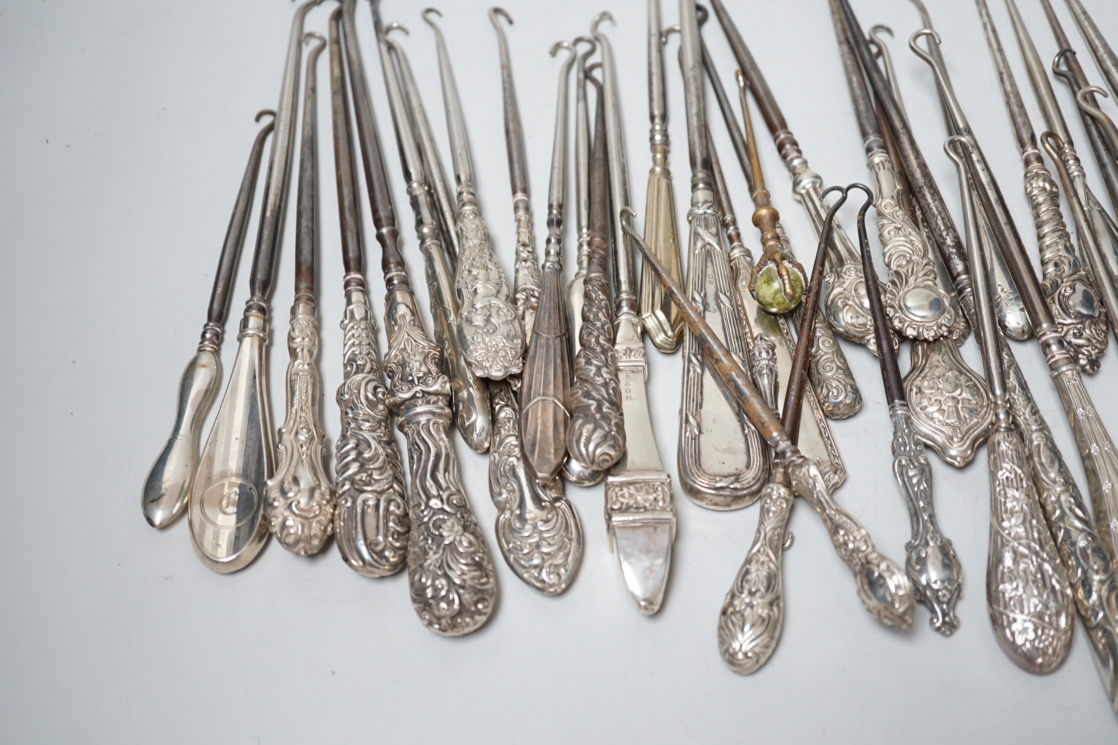 A large collection of mainly silver handled button hooks and two shoe horns.